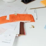 Meja kerja rapi dengan nota, dokumen transaksi, dan alat tulis untuk pencatatan bisnis